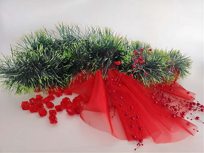 Dekorationset für Weihnachten mit grünem Tannengirlanden, roten Stoffen und Ornamenten, ideal für festliche Tisch- und Fensterdekoration.